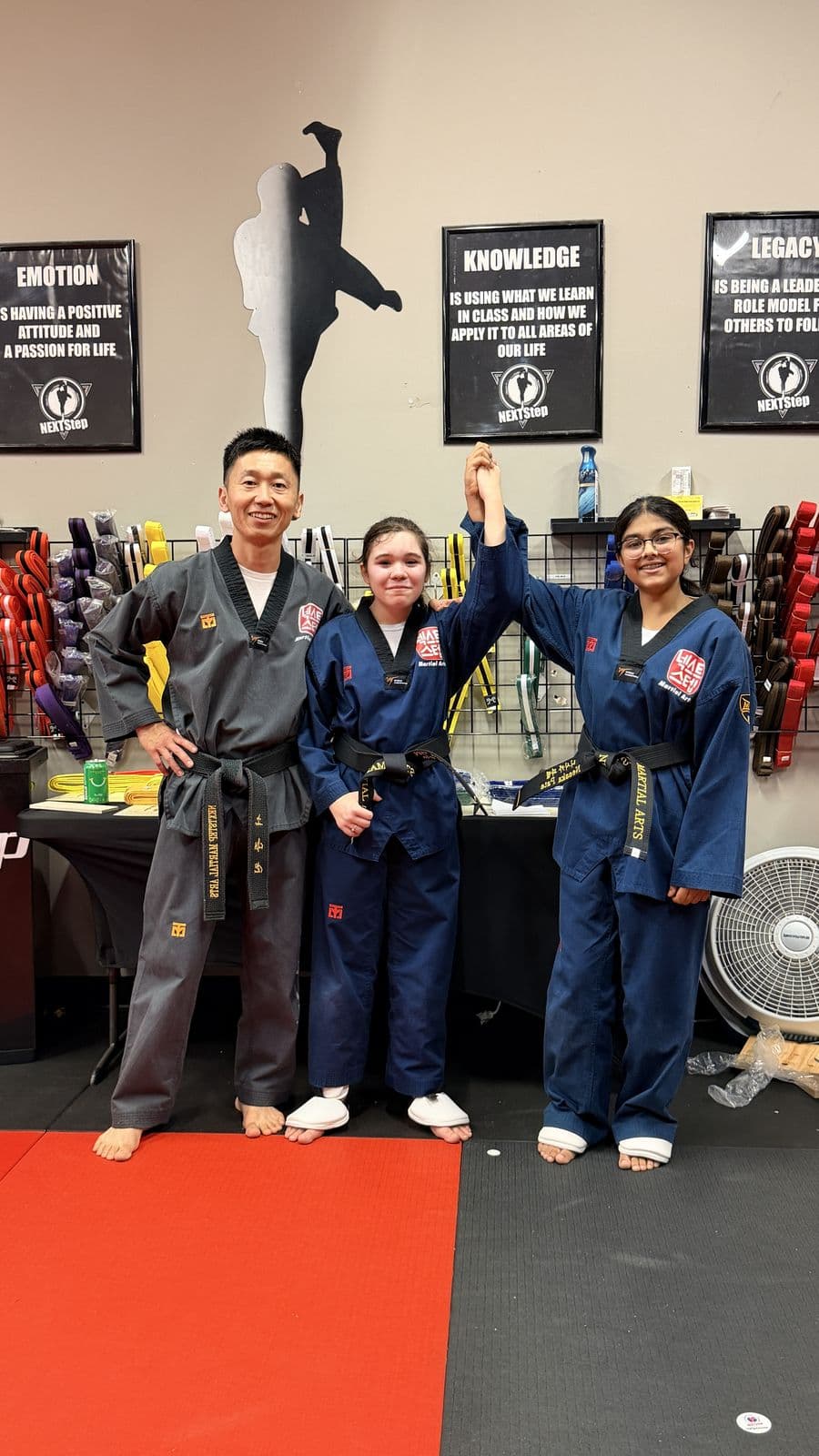 Master Jay So with two students in front of the S.E.K.L. posters