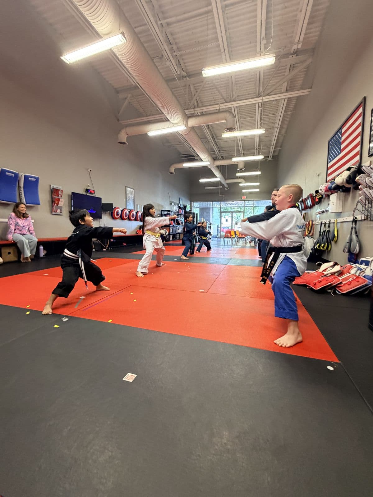 NEXTStep students practicing side kicks together on the red mats
