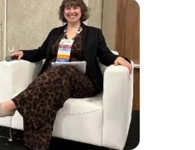 Sara Kuhn, NEXTStep adult taekwondo student, seated at a national oncology conference