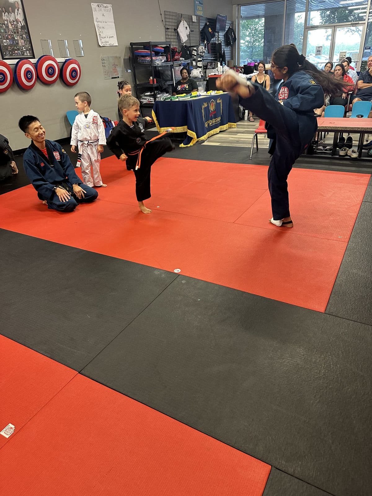 A student throwing a high kick while Master Jay watches at NEXTStep Gettysburg PA